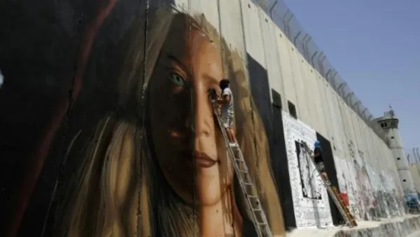 لوحة جدارية عملاقة للفلسطينية عهد التميمي قرب بيت لحم رسمها الفنان الايطالي جوريت اوغوتش 
