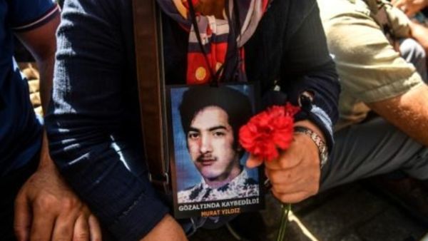 والدة تحمل صورة ابنها المفقود خلال تجمع في شارع الاستقلال في اسطنبول
