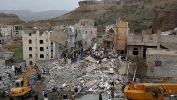 أشخاص يتفقدون ركام منزل في صنعاء دمرته غارة جوية يوم الجمعة
