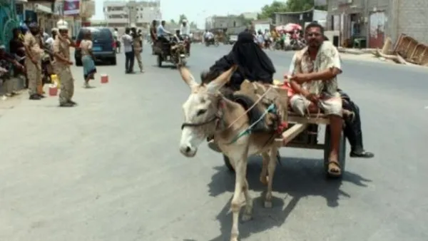 رجل وامراة على عربة يجرها حمار يعودان الى زنجبار كبرى مدن محافظة ابين جنوب اليمن بعد استعادتها من جهاديي القاعدة