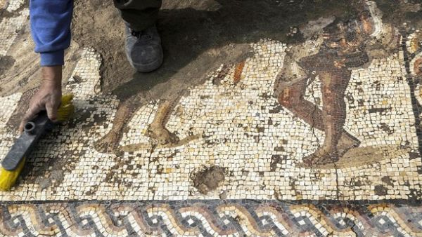 A worker from the Israeli Antiquity Authority (IAA) cleans a rare Roman mosaic from the 2nd–3rd centuries at the Israeli Caesarea National Park on February 8, 2018. (AFP Photo)