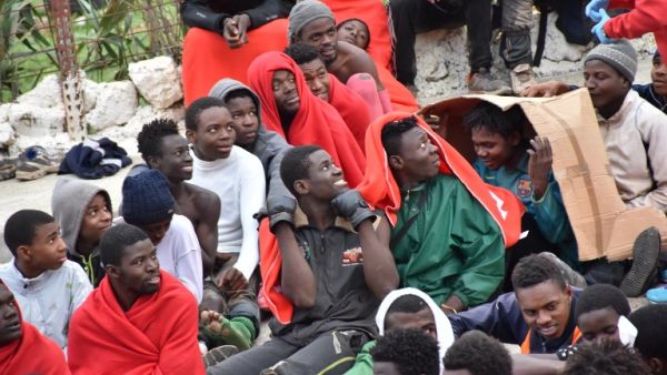 Migrants sit on the ground in El Tarajal, Ceuta, close to the border with Morocco on December 9, 2016 after being rounded up by police to be attended to by Red Cross personnel and taken to the Center for Temporary Stay of Immigrants. (AFP/ Antonio Sempere)