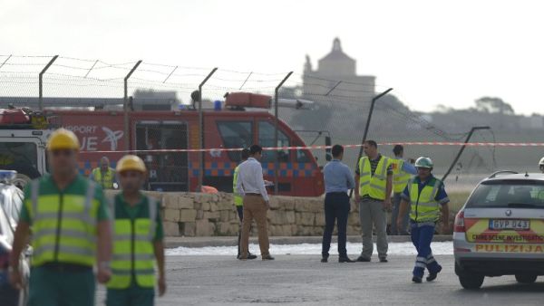 Emergency workers are seen at the site of the wreckage of a small twin engined plane which crashed shortly after takeoff from Malta International Airport, on October 24, 2016. (AFP/Matthew Mirabelli)