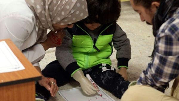The clinic provides 3D-printed limbs for amputees and disabled children like three-year-old Rowayd, using her new prosthetic arm. (AFP Photo)