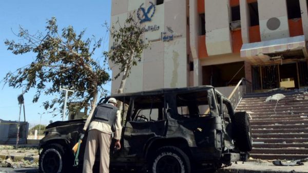 An Egyptian policeman inspects the wreckage after a car bomb blast kills three policemen in al-Tur, in the Sinai peninsula, on October 7, 2013 (AFP/Mohamed el-Shahed)