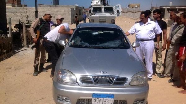 A picture taken on July 6, shows Egyptian policemen inspecting the car of a Coptic Christian priest killed in al-Arish north of the Sinai peninsula (AFP)