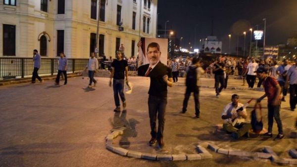 EGYPT, Cairo : A supporter of deposed president Mohamed Morsi holds a picture of him during a rally in Cairo's Six of October bridge on July 15, 2013. (AFP/MOHAMED EL-SHAHED)