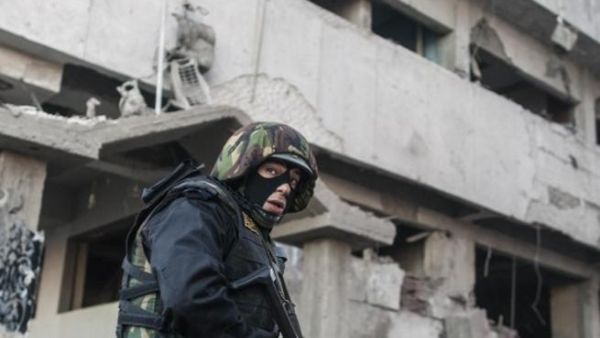  A member of the Egyptian security forces stands in front of the damaged police building following a powerful car bomb explosion in the Egyptian city of Mansura earlier this week. [AFP]