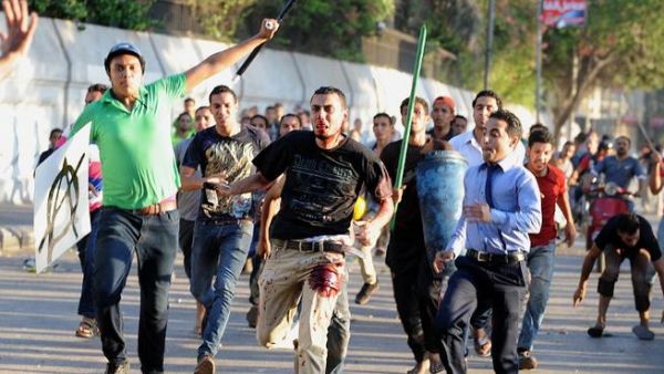 A supporter of deposed Egyptian President Mohamed Morsi is seen beaten by pro-government and army supporters during clashes. [AFP]