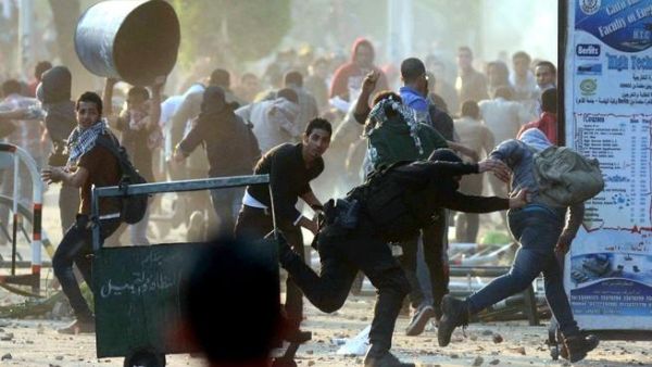 An Egyptian policeman tries to detain a student of Cairo University who support the Muslim Brotherhood during clashes with riot police in Cairo. [AFP]
