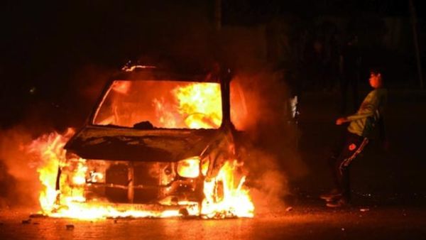 A boy kicks a burning car in Cairo on Friday as violent protests erupted between the police and those who oppose Mohamed Morsi's regime