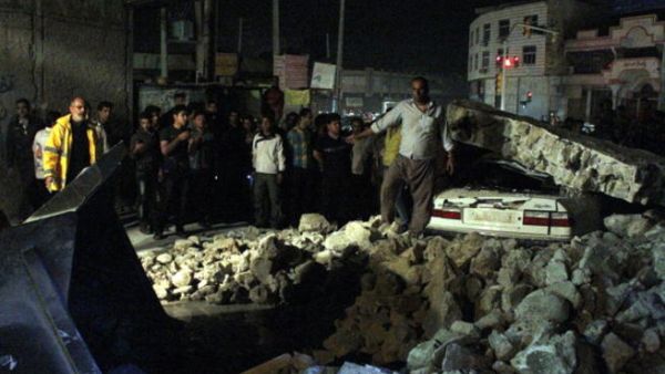 Iranians gathering amid rubble in the Iranian western city of Borazjan, on November 28, 2013, after a 5.7 magnitude earthquake struck the country. [Mohammad Salehinia/AFP]