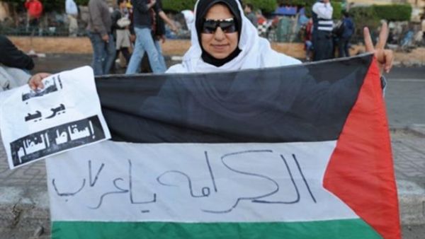 متظاهرة مصرية في القاهرة ترفع العلم الفلسطيني/أ.ف.ب