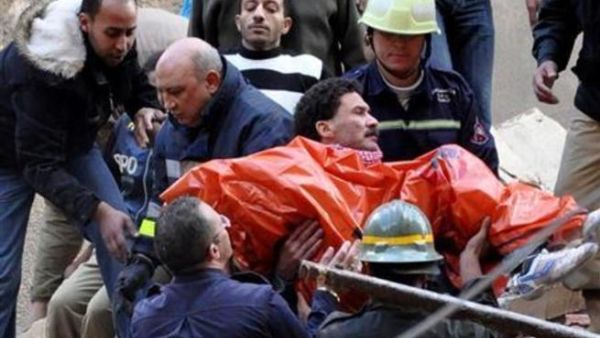 عمال الانقاذ ينتشلون جثة من بين انقاض المصنع الذي انهار بمدينة الاسكندرية المصرية