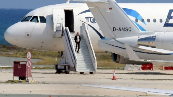 The alleged hijacker disembarks before surrendering to security forces after a six-hour standoff on the tarmac at Larnaca airport's largely disused old terminal on March 29, 2016. (AFP/George Michael)