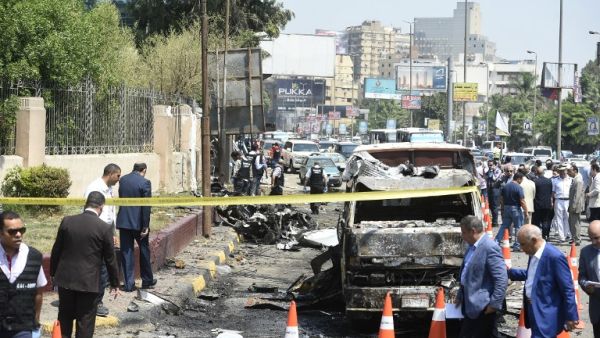 People gather as members of the Egyptian criminal lab inspect the remains of burnt vehicles in the capital Cairo on August 6, 2018. (Khaled DESOUKI / AFP)
