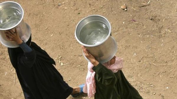 Egyptian women walk with containers filled with water in al-Rahawe Village, outside Cairo, May 27, 2010. (AFP)