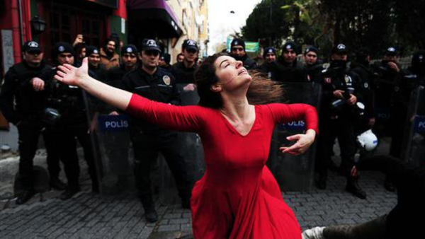 Girl in red dress dancing in front of police, a symbol of freedom from Turkey (Illustrative image) /AFP