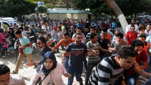 Egyptian protesters run for cover from tear gas fired by riot police during a Cairo demonstration against the handing over of two Red Sea islands to Saudi Arabia, April 25, 2016. (AFP/Mohamed el-Shahed)