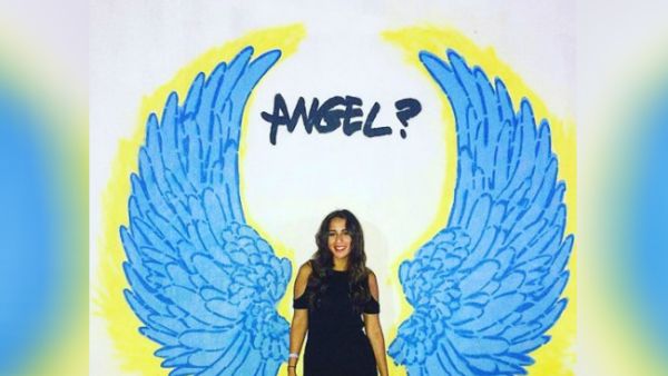 A fan stands in front of one of Radwan's murals. (Instagram / nadinkhalifa)