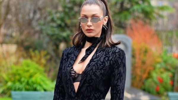 Hadid wore a mesh bodysuit and oversized 1980s power suit with a pair of white sneakers and long-length socks in what turned out to be a rather odd mix-and-match outfit. (Source: @bellahadid - Instagram)