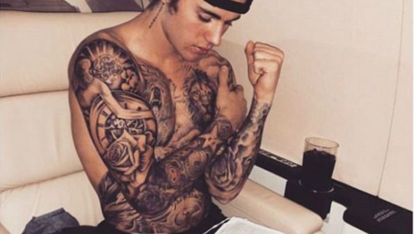 Justin made sure to show off his bulging biceps and almost fully tattooed torso in the snap as he appeared to be reading The Bible. (source: @justinbieber - Instagram)