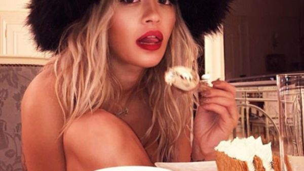 The 27-year-old singer opted for only a large oversized black fur hat as she shed the rest of her clothes to enjoy a slice of cake. (Source: @ritaora - Instagram)