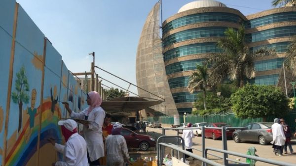 Students painting on the walls of the hospital.