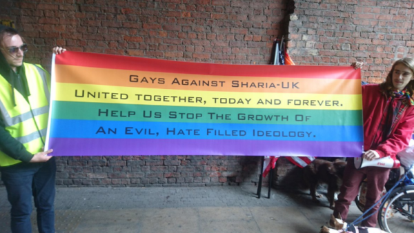 'Gays Against Sharia - UK' organizers hold up a rainbow flag during a march in Manchester (Photo: Twitter @EnglishTommy1)