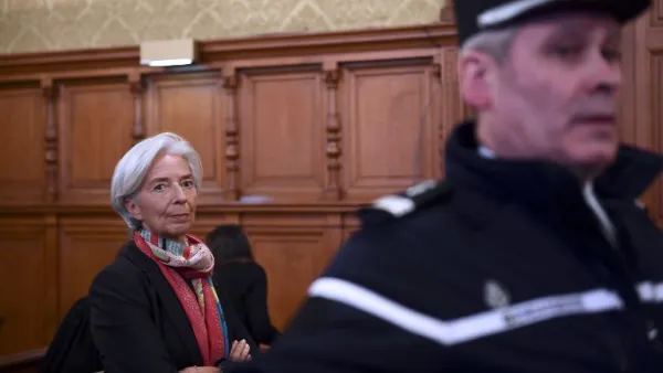 IMF chief Christine Lagarde next to a Gendarme prior to the start of her trial before the Court of Justice of the Republic, a special tribunal used to try ministers. (AFP/Martin Bureau)