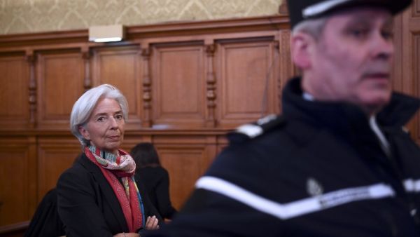 IMF chief Christine Lagarde next to a Gendarme prior to the start of her trial before the Court of Justice of the Republic, a special tribunal used to try ministers. (AFP/Martin Bureau)