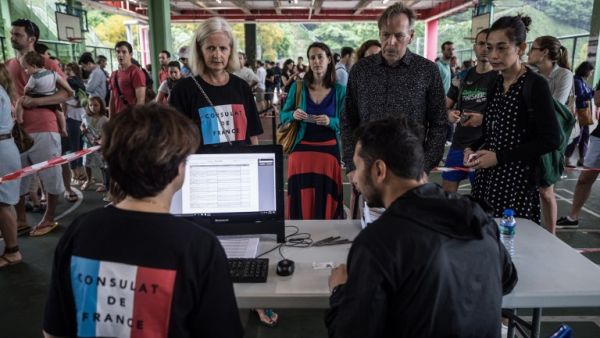 People register at a polling station during the second round of France's presidential election in Hong Kong on May 7, 2017. (AFP/Dale de la Ray)