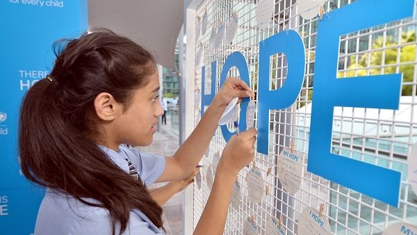 A GEMS student writes her message of hope for children around the world. 