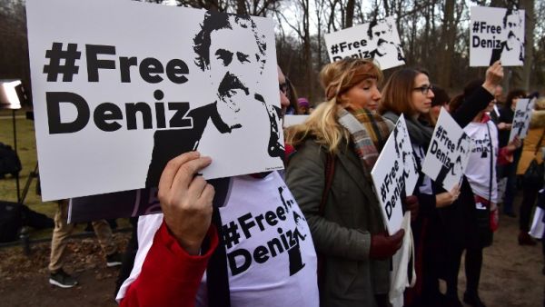 People hold placards with hashtag #FREEDENIZ to protest the detantion of German journalist Deniz Yucel in front of Turkish embassy in Berlin on February 28, 2017. (AFP/John MacDougall)