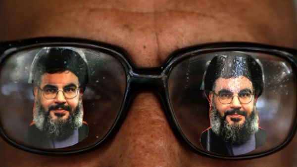 A souvenir shop owner displays glasses decorated with pictures of Hassan Nasrallah, the head of Lebanon's powerful Shiite militant group Hezbollah, in Beirut southern suburb. (AFP/File)