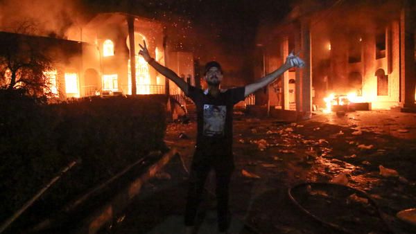 An Iraqi demonstrator poses outside the torched Iranian consulate on Friday, as protests over poor public services broke out in the city of Basra. (AFP)