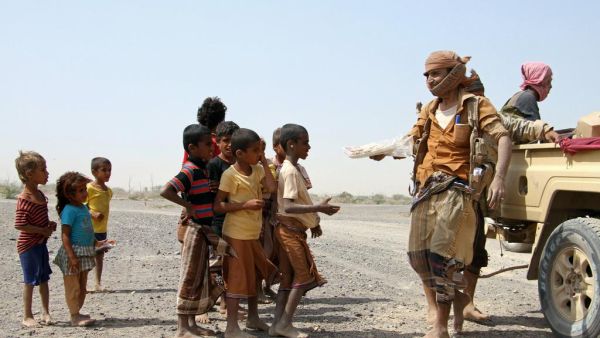 Pro-government fighters give food to Yemeni children on the road leading to the southwestern port city of Mokha on January 26, 2017. Saleh Al Obeidi (AFP)