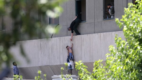 Iranian policemen evacuate a child from the parliament building in Tehran on June 7, 2017 during an attack on the complex. (Omid Vahabzadeh/Fars News/AFP) Iranian policemen evacuate a child from the parliament building in Tehran on June 7, 2017 during an attack on the complex. (Omid Vahabzadeh/Fars News/AFP)