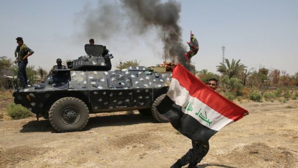 A member of the Iraqi security forces holds an Iraqi national flag in Khalidiya, east of Ramadi, the capital of Anbar province, on August 1, 2016, during ongoing fighting against Daesh. (AFP/Ahmad al-Rubaye)