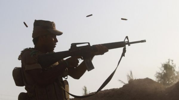 A member of the Iraqi pro-governement forces fires his weapon on a front line in the Albu Huwa area, south of Fallujah near the Euphrates river, on June 1, 2016, during an operation aimed at retaking areas from the Islamic State group. (AFP/Moadh al-Dulaimi)