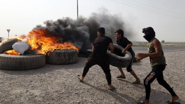 Iraqi protestors burn tyres during a gathering northwest of the southern city Basra on July 26, 2018, during a demonstration against unemployment and a lack of basic services.  (Haidar MOHAMMED ALI / AFP)