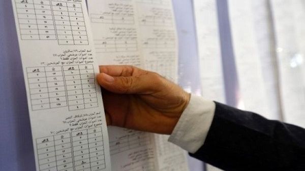 An Iraqi electoral commission official examines electronic counting machine print-outs in Najaf on May 13, 2018. (Haidar Hamdani | AFP)