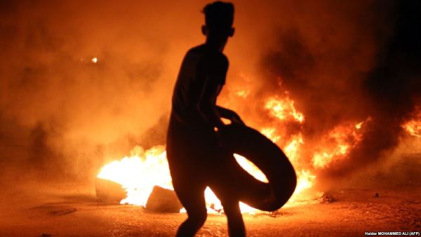 A demonstrator burns tires during protests in the southern Iraqi city of Basra on July 12. (AFP/File)