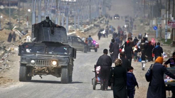 Iraqi security forces drive past civilians fleeing their homes in Mosul's old city on March 30, 2017, due to the ongoing battles between government forces and Daesh fighters. (AFP/Ahmad Gharabli) Iraqi security forces drive past civilians fleeing their homes in Mosul's old city on March 30, 2017, due to the ongoing battles between government forces and Daesh fighters. (AFP/Ahmad Gharabli)