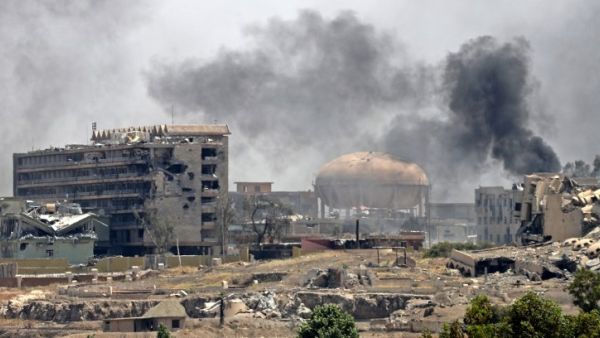 Smoke billows in a neighborhood of west Mosul's near Al-Shifa hospital (L) on May 30, 2017 during ongoing battles between Iraqi forces to retake the city from Islamic State (IS) group fighters. (AFP/Karim Sahib)