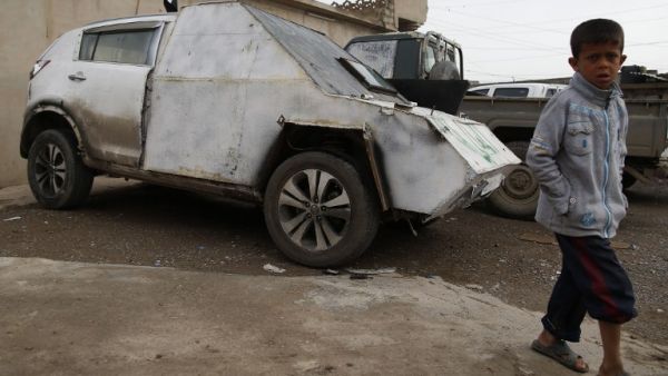 An Iraqi boy walks by a car with defused bomb in a neighborhood recently secured by Iraqi security forces in western Mosul on April 2, 2017, during the retake of the city from Daesh fighters. (AFP/Ahmad Gharabli) An Iraqi boy walks by a car with defused bomb in a neighborhood recently secured by Iraqi security forces in western Mosul on April 2, 2017, during the retake of the city from Daesh fighters. (AFP/Ahmad Gharabli)