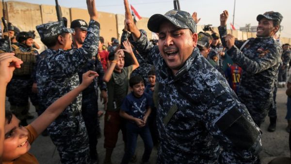 Members of the Iraqi federal police dance with children during a celebration in the Old City of Mosul, where the gruelling battle to retake Iraq's second city from Islamic State (IS) group fighters is now nearing its end, on July 2, 2017. (AHMAD AL-RUBAYE / AFP)
