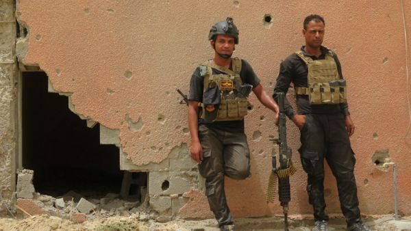 Iraqi counter-terrorism forces lean against a wall riddled with bullet holes in Fallujah. (AFP/Jean Marc Mojon)