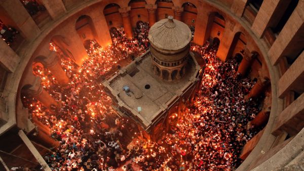 Christian Orthodox worshippers hold up candles lit from the “Holy Fire” as thousands gather in the Church of the Holy Sepulchre in Jerusalem’s Old City. (AFP/ File Photo)