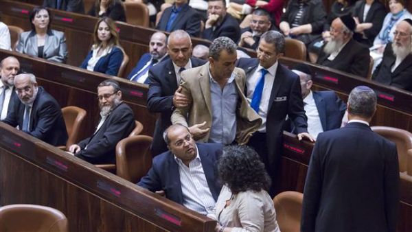 Palestinian lawmaker Jamal Zahalka is escorted to leave after he reacted to Prime Minister Benjamin Netanyahu’s speech on May 14, 2015 at the Knesset. (AFP)